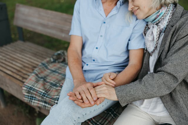 two older adults holding hands