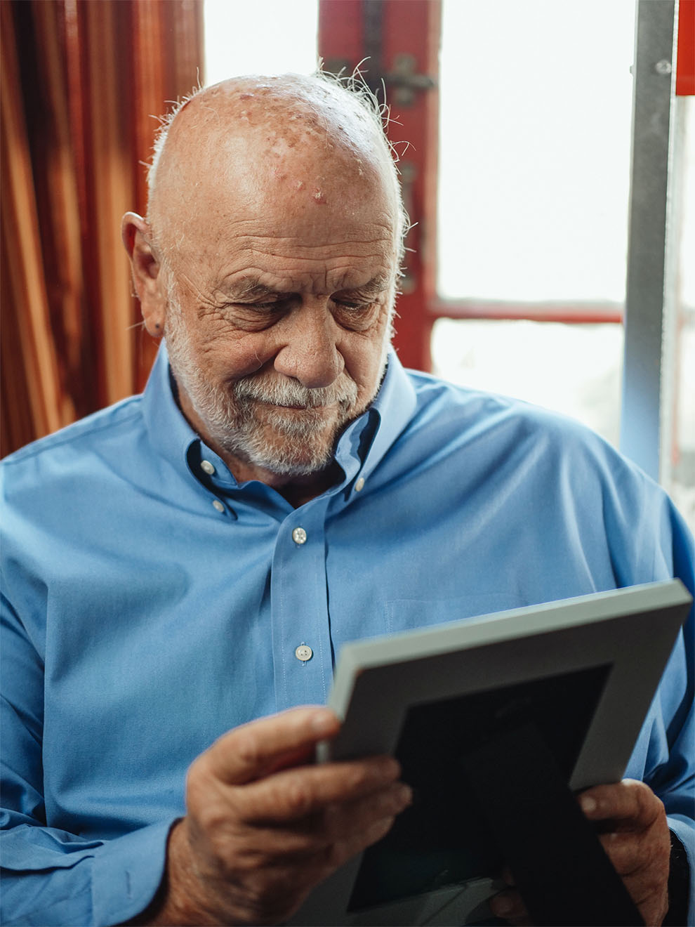 An older gentleman looking at a photograph