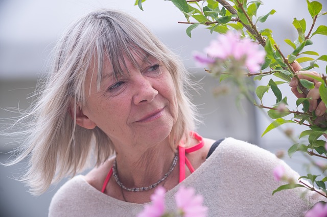 lady with blonde hair looking at flowers