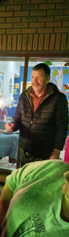 Residents and guests at Beechgrove Care Home enjoying a colourful fireworks display in the garden, surrounded by family, friends, and cosy cups of hot chocolate.