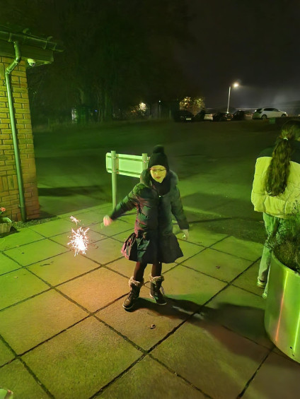 Residents and guests at Beechgrove Care Home enjoying a colourful fireworks display in the garden, surrounded by family, friends, and cosy cups of hot chocolate.