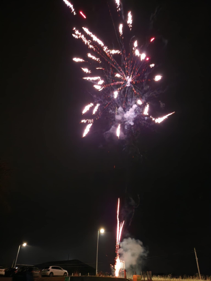 Residents and guests at Beechgrove Care Home enjoying a colourful fireworks display in the garden, surrounded by family, friends, and cosy cups of hot chocolate.