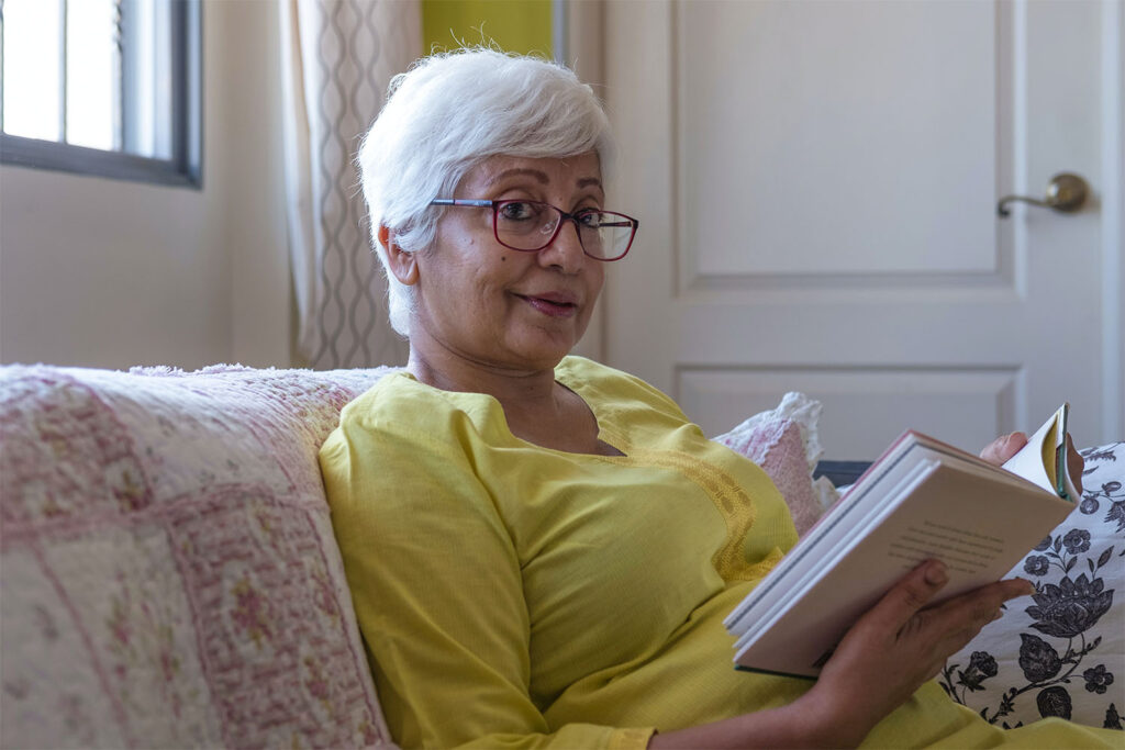 woman reading a book in a care home