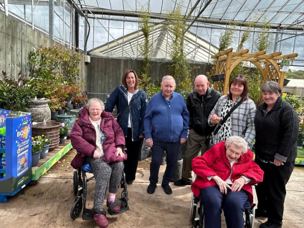 care home residents and staff in a garden centre