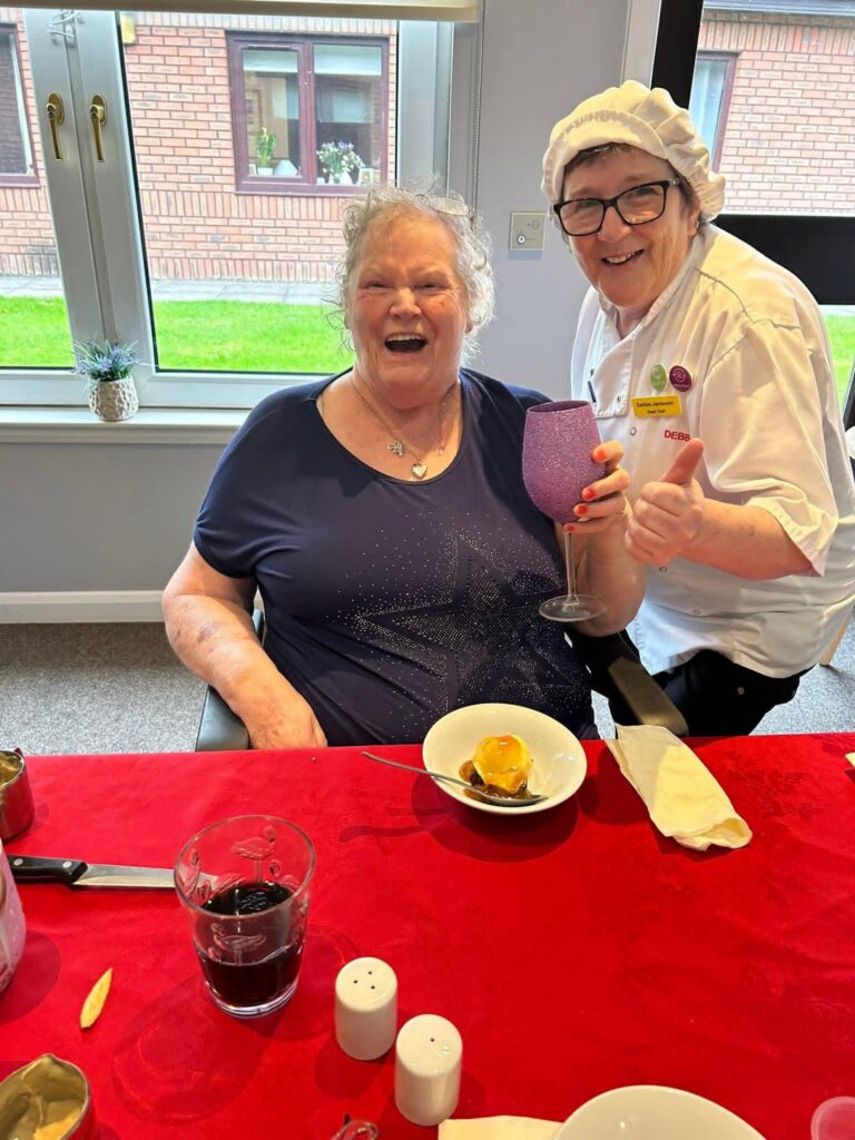 care home resident and chef laughing together