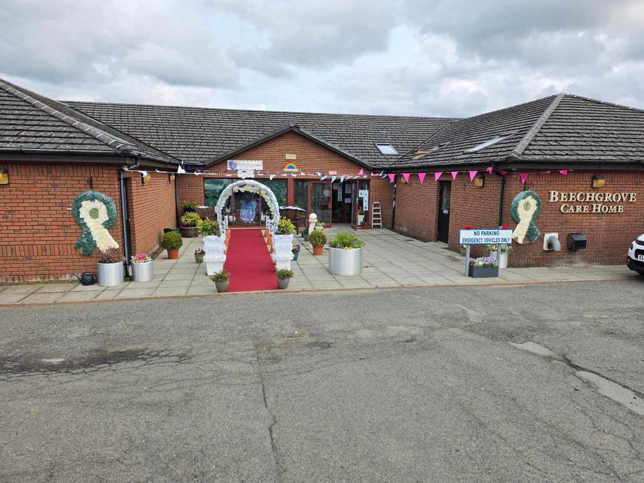 the entrance of beechgrove care home decorated with a red carpet and archway