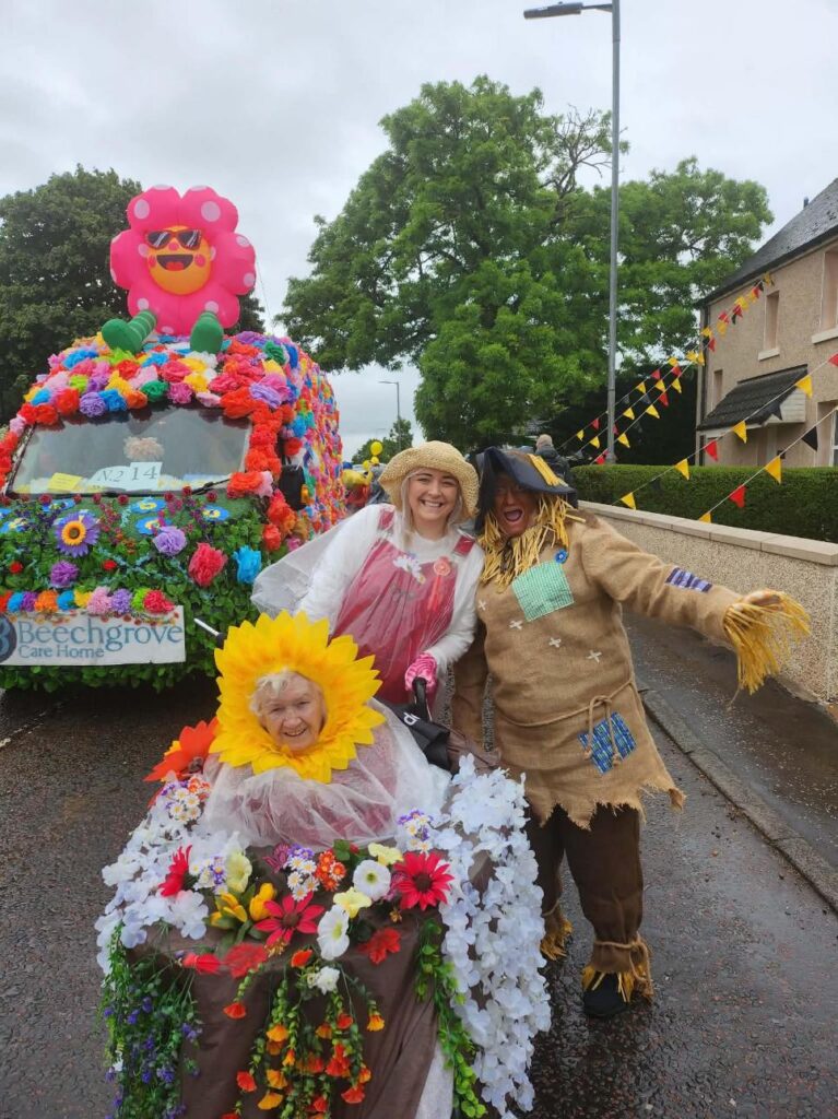 residents and staff dressed in colourful flowers on lanimers procession