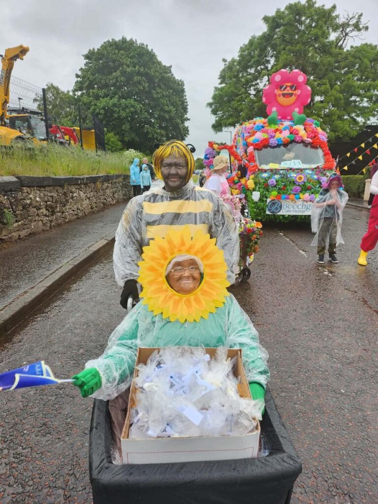 residents and staff dressed in colourful flowers on lanimers procession