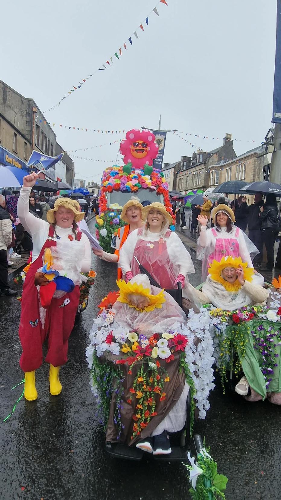 residents and staff dressed in colourful flowers on lanimers procession