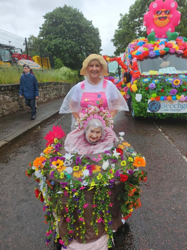residents and staff dressed in colourful flowers on lanimers procession